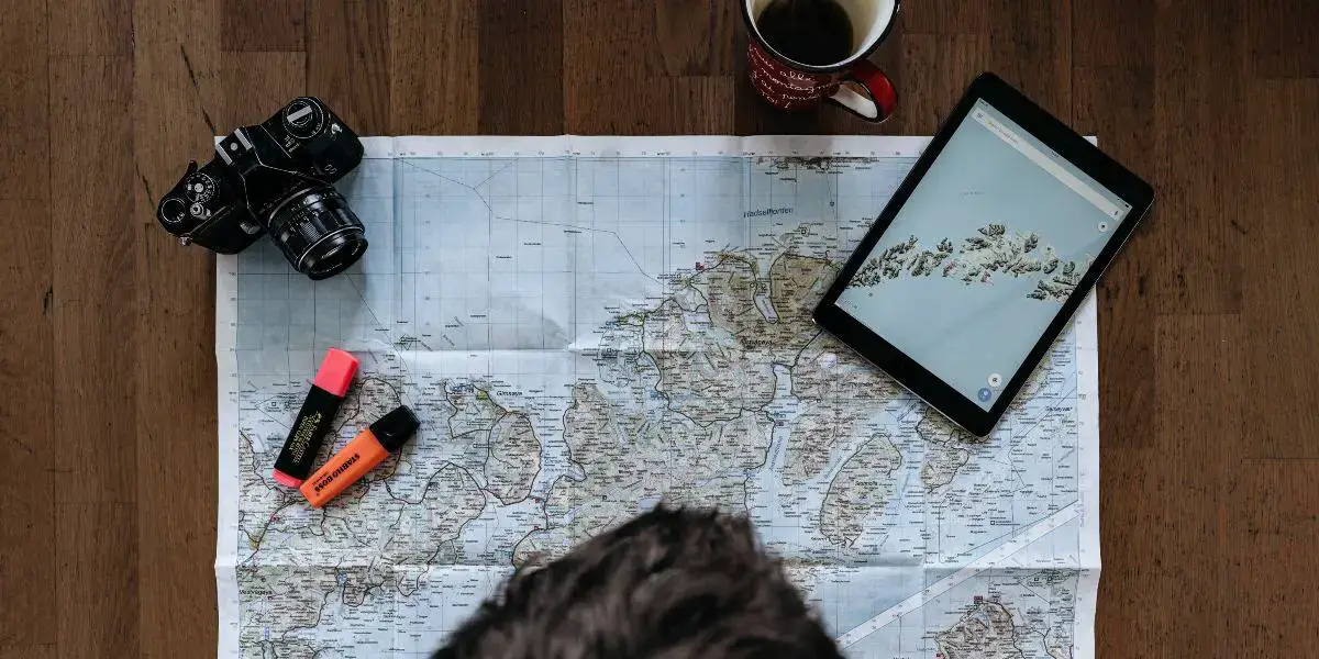 Image of man looking at a road map about to make a road trip plan