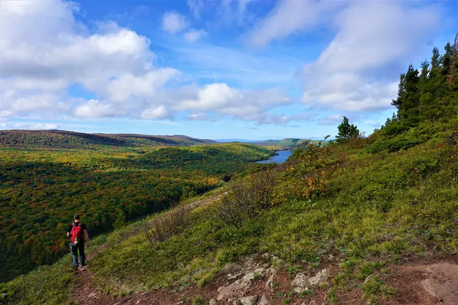 Image of hiking the Escarpment Trail in the Porcupine Mountains. Lake of the Clouds can be seen in the distance