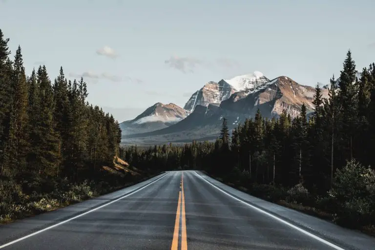 Open road with snow topped mountains in background