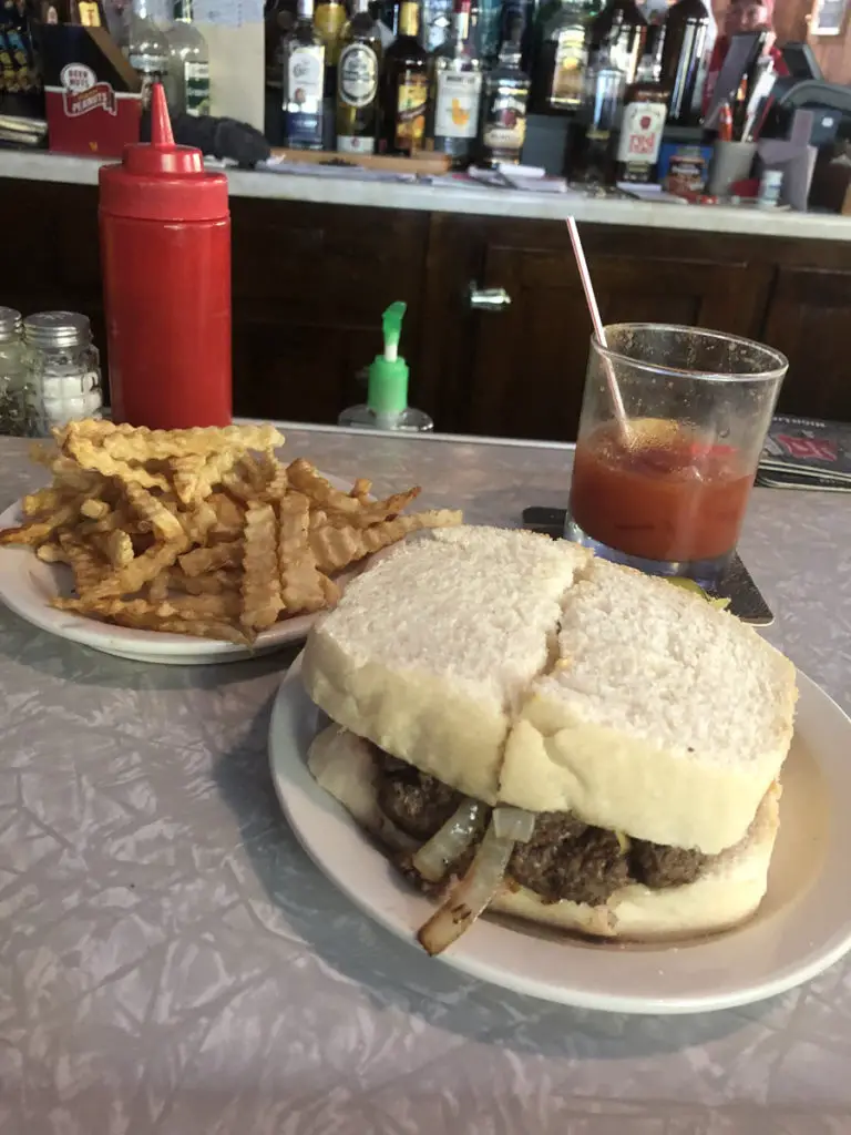 Image of hamburger with raw onions on homemade white bread at Birminghams bar in Sturgeon Bay WI