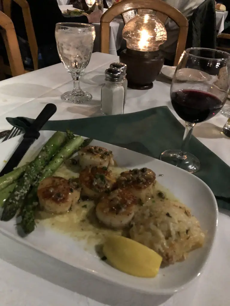 Image of dinner at Donnie's Glidden Lodge: scallops, asparagus, and a glass of wine