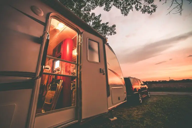Image of a travel trailer with the sun setting in the background