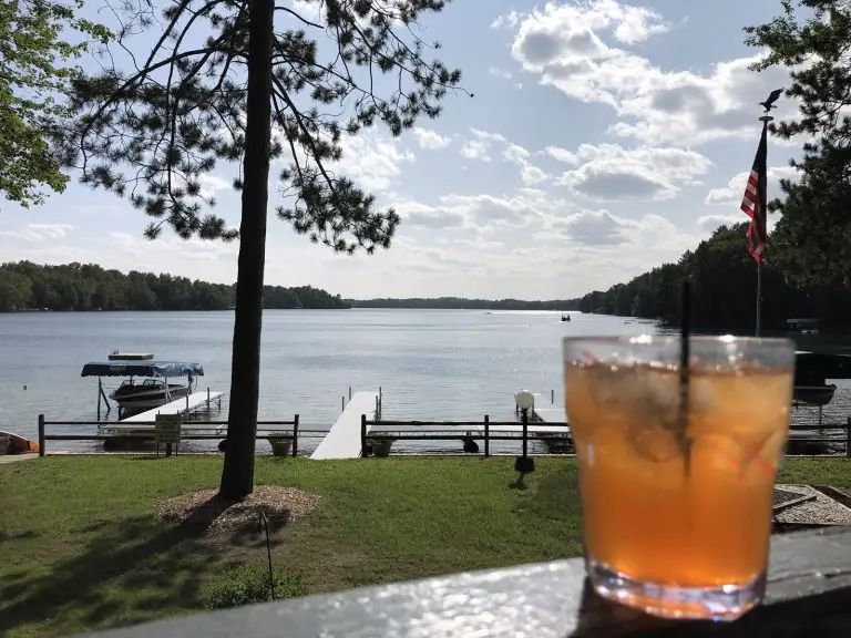 Image of old fashioned drink glass on railing overlooking Maiden lake