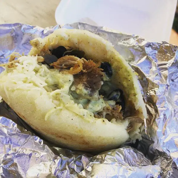 Image of arepa with cheese, pork, beans, and garlic salsa from Anytime Arepa in Milwaukee,  WI