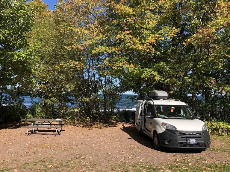 Image of Union Bay Campground Michigan. Van is parked at campsite along Lake Superior