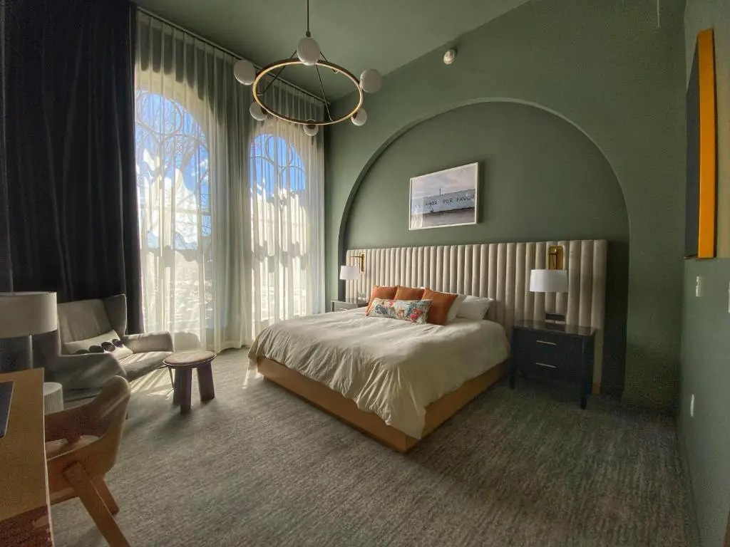 Image of room at Kinn Guesthouse Downtown with tall windows and a pale green decor