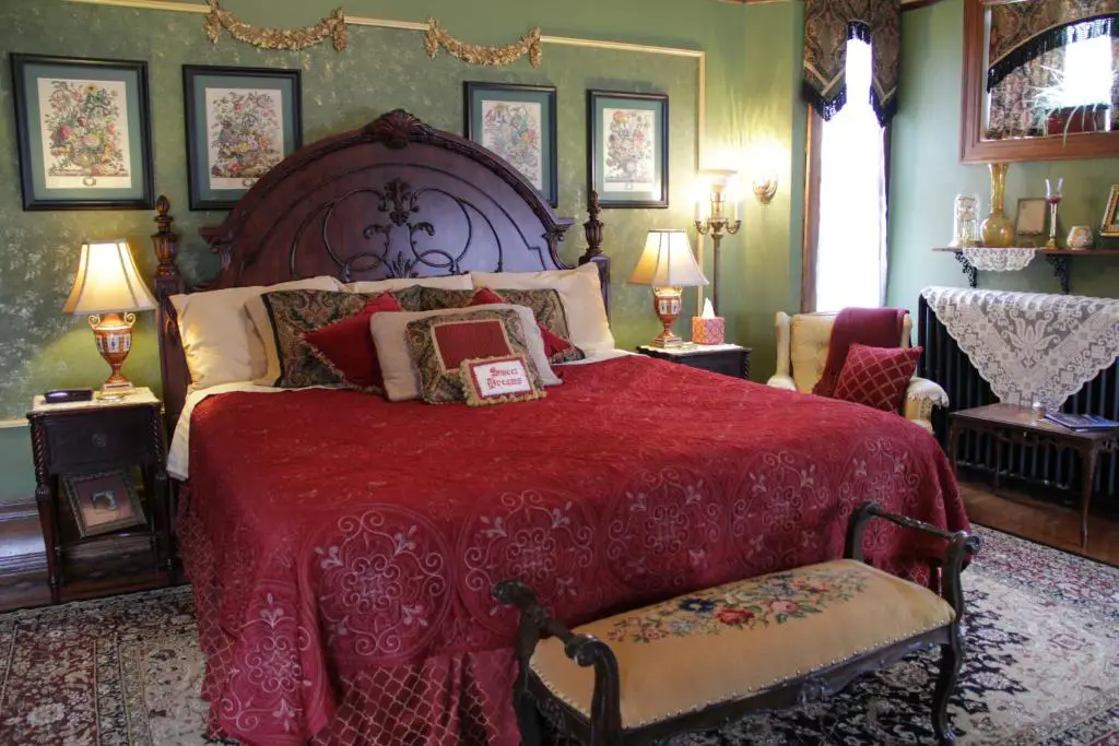 Image of room at Shuster Mansion with red bed spread and a green walls